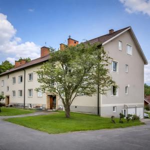 una grande casa bianca con un albero in cortile di You Can Sleep Here a Hävla Bruk