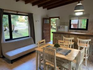 een woonkamer met een tafel en een bank bij Bosque y Playa en casa in Carilo