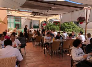 eine Gruppe von Menschen, die an Tischen in einem Restaurant sitzen in der Unterkunft Hôtel Belleville in Lamalou-les-Bains + 21 Fotos