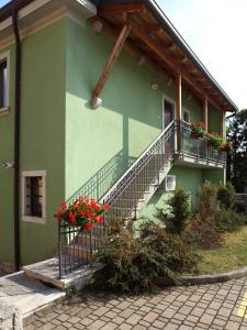 迪瓦采的住宿－Bed and Breakfast Malovec，一座绿色的建筑,上面有楼梯和鲜花