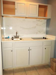 una cucina con mobili bianchi e un lavandino di Americas Best Value Inn Suites & Studios Blytheville by Sonesta a Blytheville Altre 33 foto