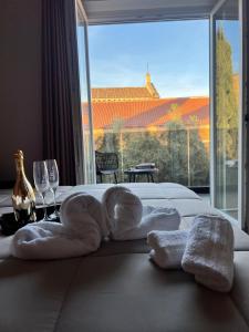 ein Hotelzimmer mit Handtüchern auf einem Bett mit einem großen Fenster in der Unterkunft 50 Passi dal Duomo in Marcianise