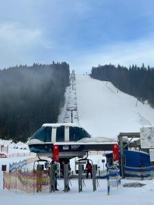 a snow covered ski slope with a ski lift at Beskyd Suites in Bukovel