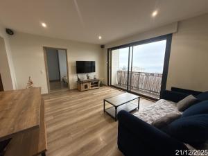 ein Wohnzimmer mit Couch und großem Fenster in der Unterkunft Le Turgot, proche thermes in Thonon-les-Bains