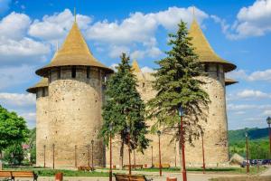two towers of a castle with trees in front at Apartament modern plaja Nistrului in Soroca