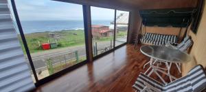 ein Zimmer mit Tisch und Blick auf das Meer in der Unterkunft Casa en la playa in Valdivia