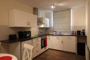 a kitchen with white cabinets and a counter top at Salisbury Renovated Apartment in Belfast