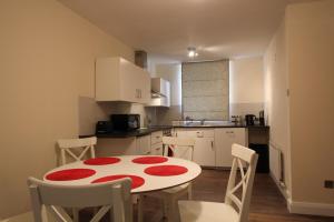 cocina con mesa y sillas rojas y blancas en Salisbury Renovated Apartment, en Belfast