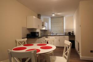 a kitchen with a red and white table and chairs at Salisbury Renovated Apartment in Belfast