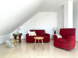 a living room with two red chairs and a table at Penthouse Jul&Mel in Valle Gran Rey