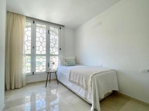 a white bedroom with a bed and a window at Penthouse Jul&Mel in Valle Gran Rey