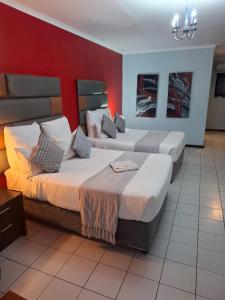 En eller flere senge i et værelse på Africa Lodges