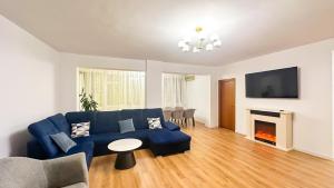 a living room with a blue couch and a fireplace at Zarii Suites- Cotroceni in Bucharest
