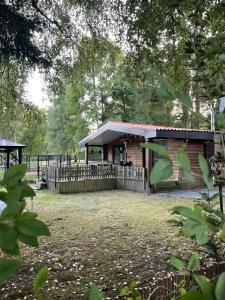 a building with a fence in a yard with trees at La Luna in Lanaken