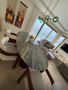 een tafel en stoelen in een woonkamer met een groot raam bij Carrousel Atlantic View in Rabat