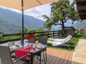 - une table et des chaises sur une terrasse avec vue dans l'établissement Casa Nenella, à Paesana