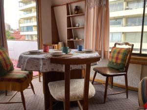 un tavolo e delle sedie in una stanza con una finestra di Terraza CasaOcho a Viña del Mar