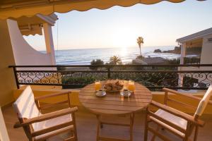a table and chairs on a balcony with a view of the ocean at Glyfada Glow Suites by CorfuEscapes in Glyfada