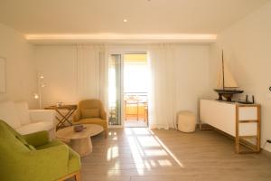 a living room with a couch and a table at Glyfada Glow Suites by CorfuEscapes in Glyfada