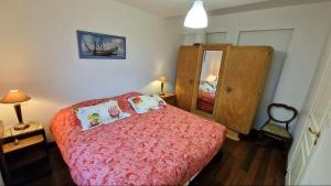 a bedroom with a bed with a red bedspread at Magnifique T3 RDC vue mer-accès plage direct chez CATH in Trébeurden