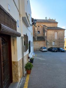 een straat met een gebouw en een gebouw met auto's bij CA TERESINA l RELAX RURAL in Montesa