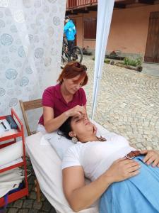 une femme allongée dans un lit à côté d'une autre femme dans l'établissement Casa Nenella, à Paesana