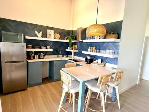 una cucina con tavolo, sedie e frigorifero di Lantana Sea La Vie - by ZenBreak a Saint James