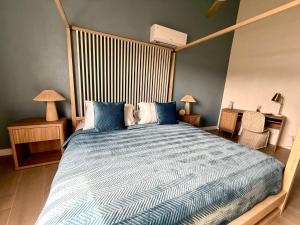 una camera da letto con un letto grande con un piumone blu di Lantana Sea La Vie - by ZenBreak a Saint James Altre 29 foto