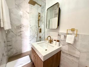 a white bathroom with a sink and a mirror at Lantana Sea La Vie - by ZenBreak in Saint James