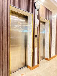 due porte dell'ascensore in un edificio con un orologio di فندق اصيلة الاندلس a Muzdalifah