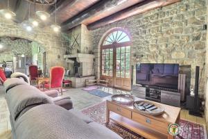 een woonkamer met een grote stenen muur bij CHATEAU ROUSSET in St Apollinaire De Rias