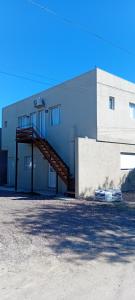 un edificio con una scala sul lato di Brusa 1 a Las Grutas 1 altra foto