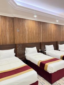 due letti in una stanza con pareti in legno di فندق اصيلة الاندلس a Muzdalifah