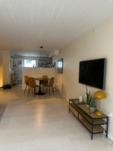 ein Wohnzimmer mit einem Tisch und einem Flachbildfernseher in der Unterkunft Apartment near Utzon in Aalborg + 6 Fotos