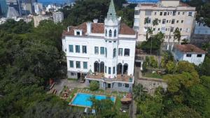 an aerial view of a large white house with a pool at Castelo dos Tucanos Host in Rio de Janeiro