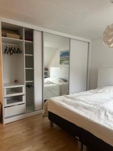 ein Schlafzimmer mit einem Bett und einem großen Spiegel in der Unterkunft Apartment near Utzon in Aalborg