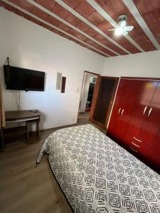 ein Schlafzimmer mit Bett und Flachbildfernseher in der Unterkunft Kitnet mobiliado no Caiçara, de fácil acesso ao centro e shopping in Belo Horizonte