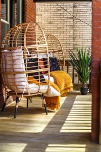 a couple of wicker chairs sitting on a patio at Jungle House Luxury Stays - Columbus Downtown Short North in Columbus
