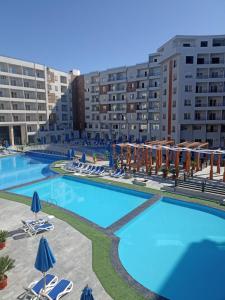 una gran piscina con sillas y sombrillas en Tiba Golden beach resort hurghada down town, en Hurghada