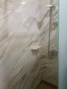 Un baño con ducha con paredes de mármol blanco. en Tiba Golden beach resort hurghada down town, en Hurghada