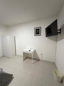 a white room with a table and a tv on the wall at B&B Boffa in Buccino