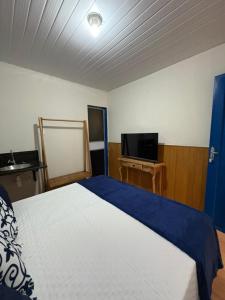 una camera da letto con un letto e una TV a schermo piatto di Pousada Dom Luiz a Ouro Preto