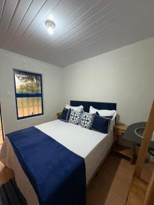 una camera da letto con un letto con lenzuola blu e una finestra di Pousada Dom Luiz a Ouro Preto