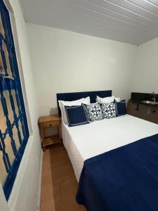 una camera con 2 letti con cuscini blu e bianchi di Pousada Dom Luiz a Ouro Preto Altre 7 foto