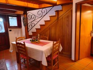 a dining room with a table and a staircase at Baitin Laf in Grosio