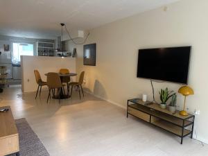 ein Wohnzimmer mit einem Tisch und einem TV an der Wand in der Unterkunft Apartment near Utzon in Aalborg