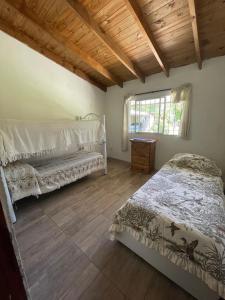ein Schlafzimmer mit zwei Betten und einem Fenster in der Unterkunft Casa de verano in Mar del Plata