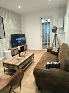 ein Wohnzimmer mit einer Couch und einem Couchtisch in der Unterkunft L'Eucalyptus in Saint-Nicolas-dʼAliermont