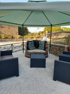a couch sitting under a tent in a patio at La Longère des Oies in Saint-Thibault