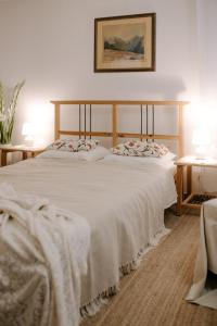 a bedroom with a large white bed with two pillows at Willa Tyrolczyk in Karpacz